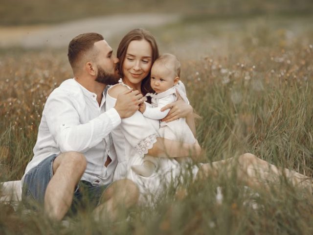 Happy family enjoying quality time in a serene meadow setting.