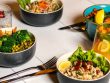 A vibrant assortment of healthy bowls and drinks showcasing fresh ingredients like broccoli and citrus.